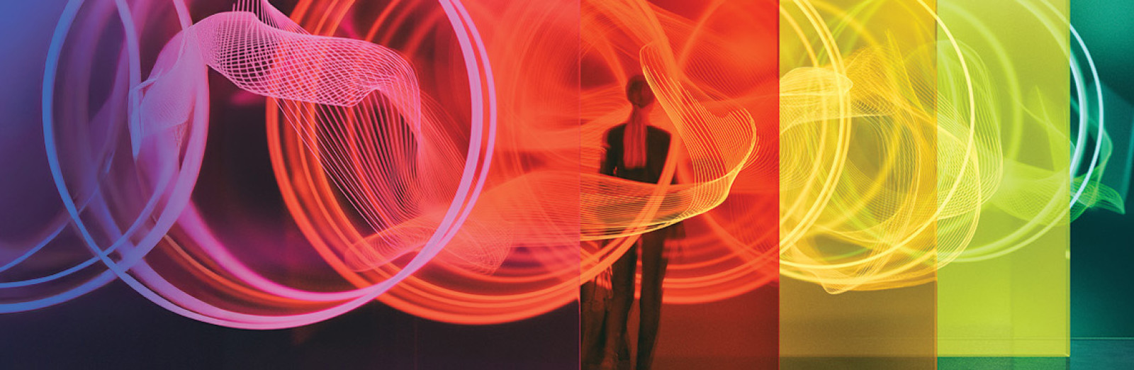Business person standing in front of abstract multicoloured background